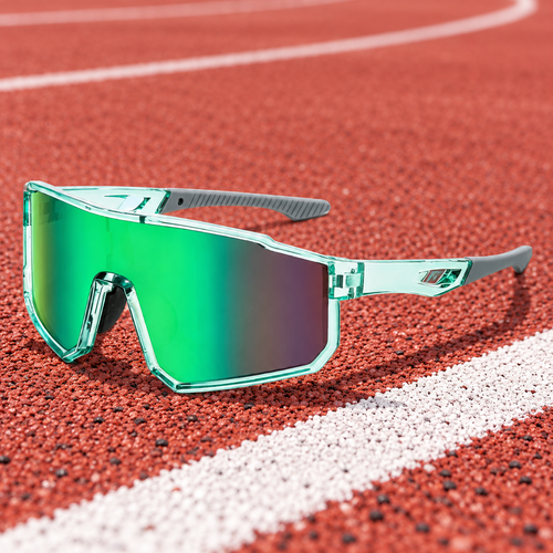 Green Shield Sport sunglasses resting on a running track