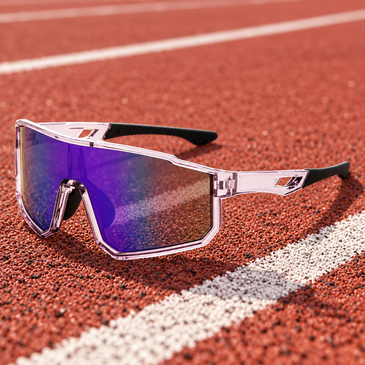 Purple Shield Sport sunglasses resting on a running track