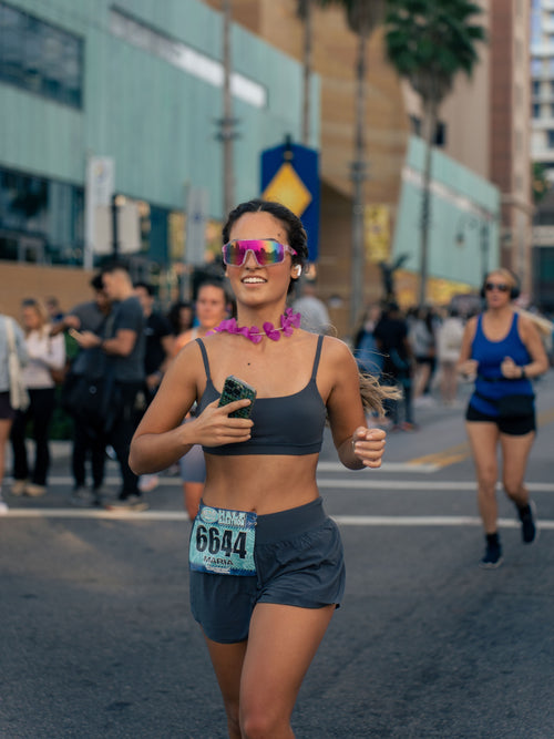 Runner in a city race wearing pink mirrored shield sunglasses