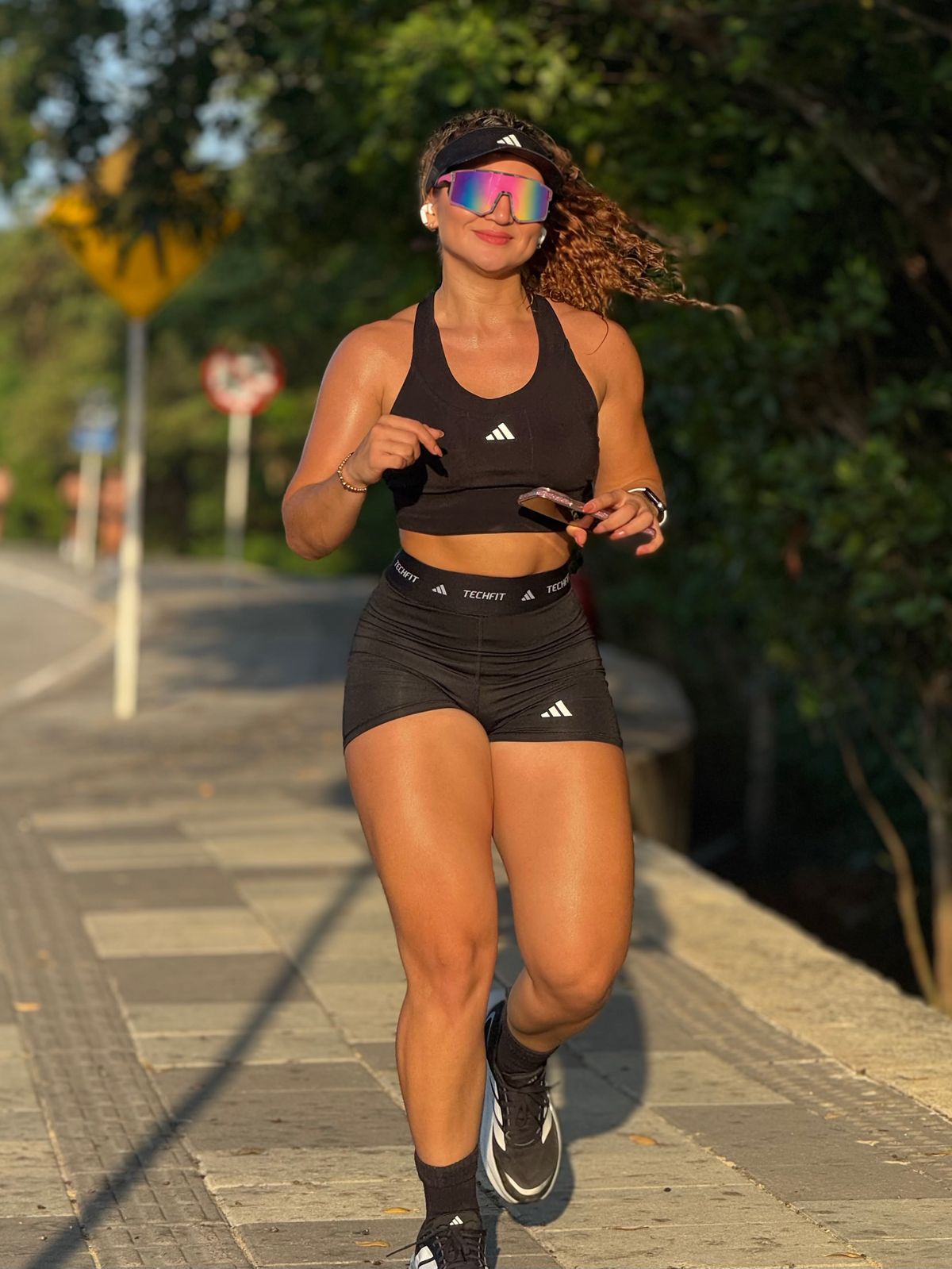 Runner on a sunlit path wearing pink mirrored shield sunglasses